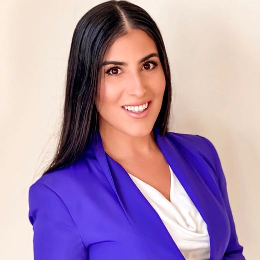 Headshot of owner of Gabinsurance, Gabriela, in a white shirt and a purple blazer