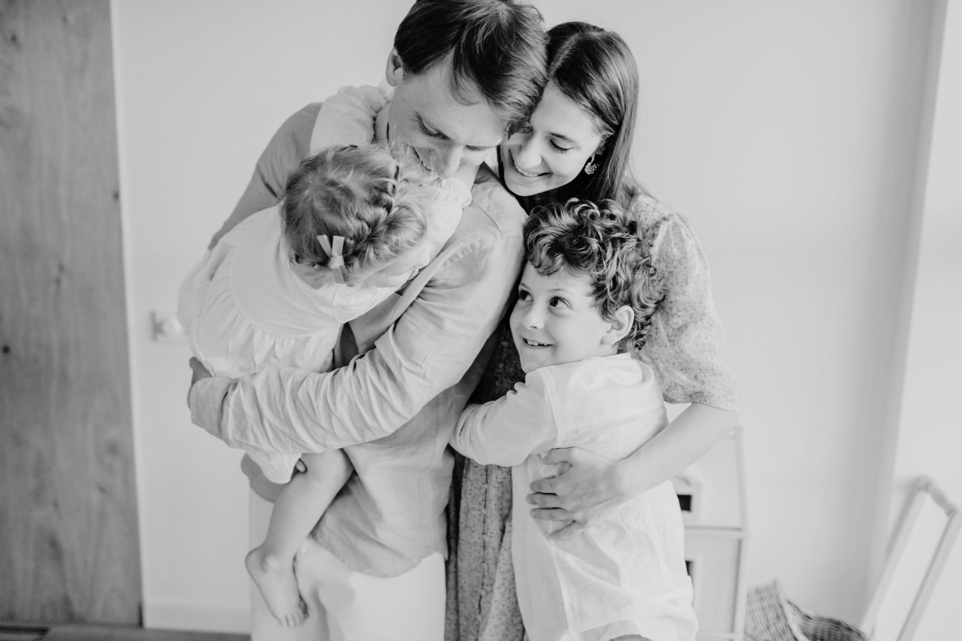 A photo of a family of four hugging.